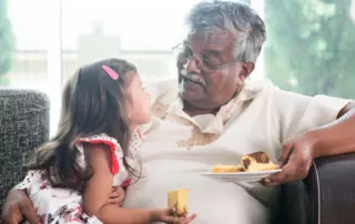 Grandfather and granddaughter eat cake