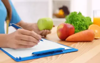 a nutritionist writes on a clipboard