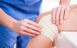 Provider examining a wrapped knee