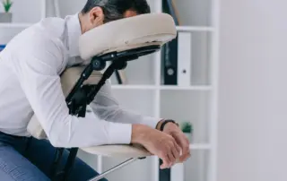 Male receiving chair massage at work