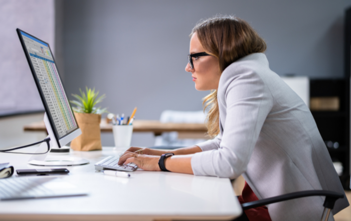 woman at computer hunched over her desk with bad posture