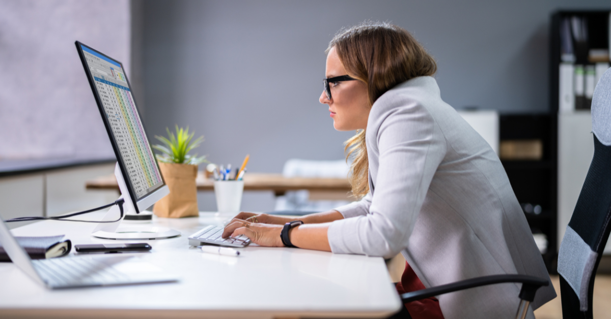 woman at computer hunched over her desk with bad posture