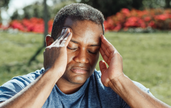 person holding their head with headache pain