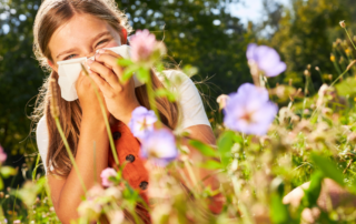 girl in flower field sneezing