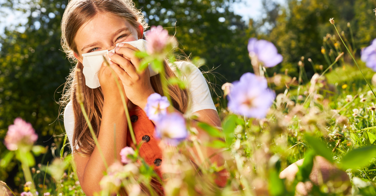 girl in flower field sneezing