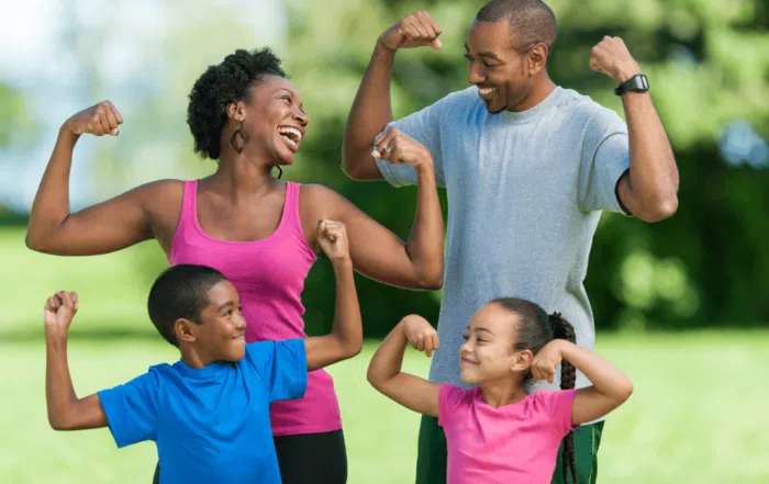 family flexing muscles and smiling