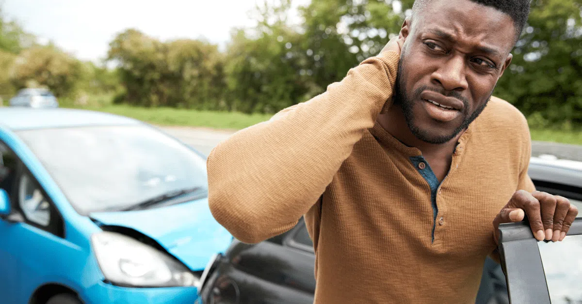 man by a car after an auto injury