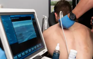 Patient receiving ultrasound during trigger point injection at BackFit