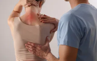 person with upper back pain getting medical exam